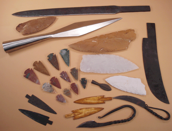 Various arrowheads, spear points, axe, adze, and knife blades made from knapped stone, bone, and forged metal. Arrow, knife, and spear making supplies. 