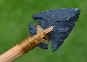 hafted stone indian arrowhead on shaft