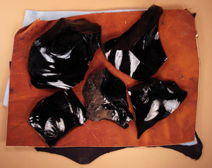 black obsidian spalls on leather flintknapping pads