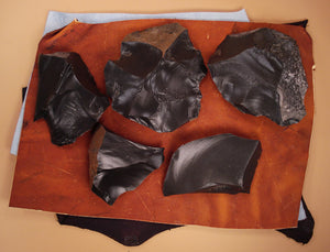 Dacite rock spalled and cleaned on top of flintknapping leather pads